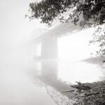 Heavy morning fog on the Potomac River adds mystery to this otherwise peaceful water scene. B&W photo of the Point of Rocks Bridge over the Potomac River in Virginia
